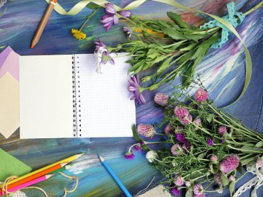 Sanat malzemeleri, Not defteri ve kireçli bir mavi arka plan, sonbahar ve okul, üstten görünüm kavramı üzerinde çiçekler parlak dekoratif bileşimi