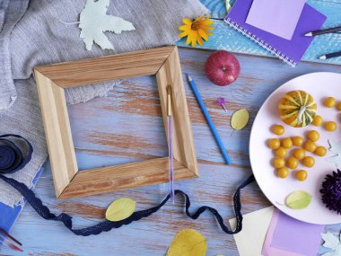 Dekoratif kabak, taze çiçekler, yapraklar ve sanat malzemeleri ahşap mavi arka plan, üstten görünüm üzerinde Cadılar Bayramı kutlamak için hazırlık için sonbahar düzenlenmesi