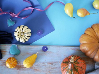 Pumpkins, armut, mor eldivenler, mumlar ve farklı dokular, üstten görünüm, helloween, bir ev mevsimlik tatil için hazırlık kavramı mavi bir arka plan üzerinde keçe kalp dekoratif bileşimi