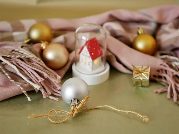 Weißes Spielzeughaus Mit Rotem Dach Warmem Schal Weihnachtskugeln Auf Hellgoldenem — Stockfoto