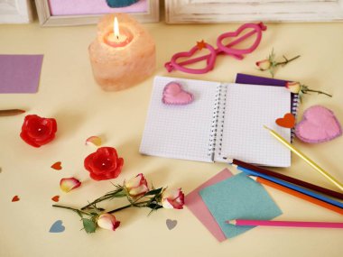 Sevgililer, düğün, Doğum--dan taze gül, gül yaprakları, keçe kalpleri ile kutlama için dekoratif kompozisyon mumlar, boş defter kayıtları, kağıt, kalem üzerinde hafif bir arka plan, üstten görünüm için yaktı.