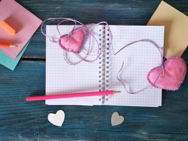 Sevgililer günü, mavi ahşap bir masa, boş bir defter, çerçeveler, kalemler, kalpler, yer imleri, hazırlık kavram hissettim bir romantik tatil, dekoratif kompozisyon, üstten görünüm