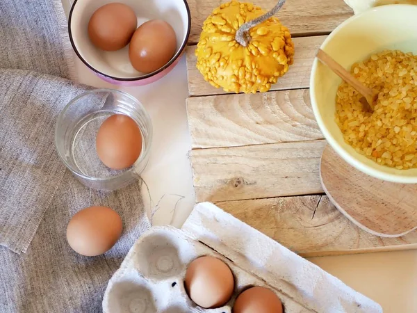 Eggs, pumpkins, sea salt on a light table, top view, home cooking ingredients, shades of yellow