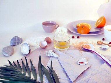 Deniz tuzu, dilimlenmiş portakal, yumurta, deniz taşları ve kabukları parlak bir tablo, en iyi görünüm, bir maske için malzemeler üzerinde fırçalayın, bakım prosedürleri nazik