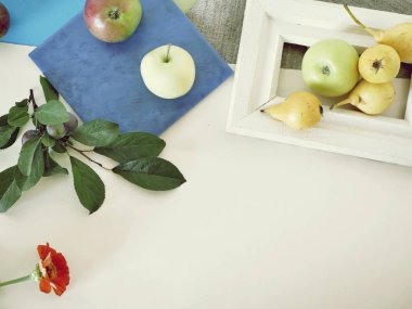 Sarı armut ve elma Beyaz ahşap çerçeve, yaprakları, mevsimlik yaz kompozisyona hafif bir arka plan, üstten görünüm, sağlıklı bir yaşam tarzı kavramı