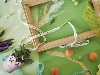 Dekoratif bir mevsimlik meyve, dekor, yeşil ve yeşil renkli kağıt, ahşap bir boş çerçeve kompozisyonu boyalı pastel ile Üstten Görünüm