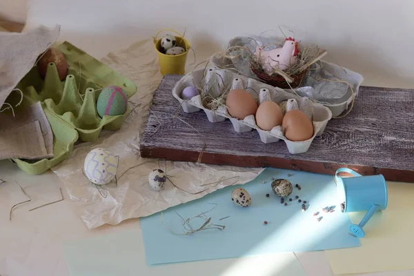 Chicken and quail eggs, toy chicken, hay, Easter decor on a light background