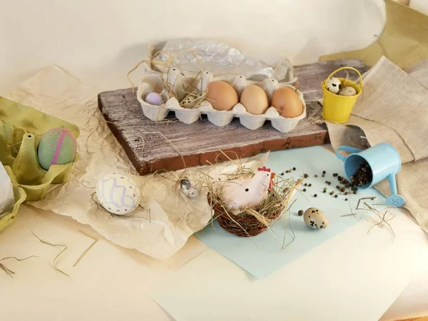 Chicken and quail eggs, toy chicken, hay, Easter decor on a light background