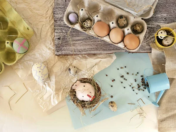 Chicken and quail eggs, toy chicken, hay, Easter decor on a light background