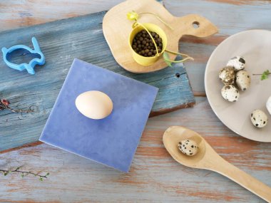 Mavi ahşap masada yumurta, bıldırcın, Paskalya dekoru, üst görünüm