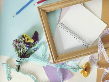 Kağıt, boş defter, küçük buket, masanın üzerinde kalemler, üst görünüm, çalışmanın başlangıcı veya sonu, tebrikler