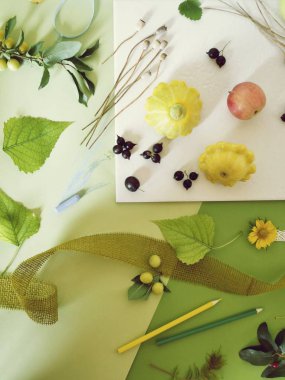 Beyaz bir tabak ve yeşil renkli kağıt üzerinde meyve, sebze, çiçek yaz mevsim kompozisyonu, pastel ile boyanmış, üst görünümü