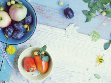 Taze sebzeler, meyveler, çiçekler, tahta bir masada yapraklar, üst görünüm, sağlıklı gıda hazırlama, yaz