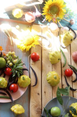 Piyasa paketi, sağlıklı gıda, yaz ve sonbahar mevsiminden ahşap bir masa üzerinde parlak taze sebze, meyve ve çiçekler