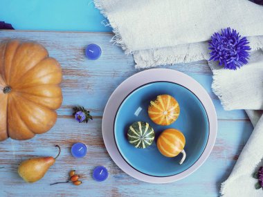 Kabaklar, mumlar, çiçekler ve bez masada, üst görünümü, sonbahar mevsimlik tatil, Cadılar Bayramı için iç dekorasyon