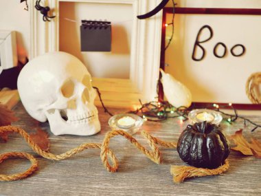 Kafatası, kabak, yanan mumlar, aydınlatma, yaprakları ve gri ahşap masa ve hafif bir arka plan üzerinde mistik dekor dekoratif kompozisyon, Cadılar Bayramı, sonbahar, Ekim