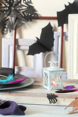 Mistik dekor, dekoratif bir fener yanan bir mum, çerçeveler, ahşap bir masa üzerinde sonbahar yaprakları, Cadılar Bayramı için iç hazırlık, Ekim