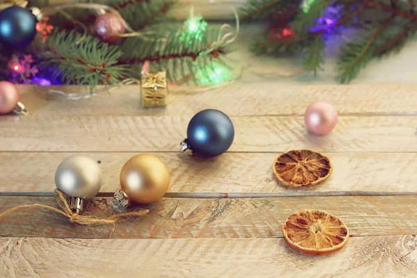 イルミネーションクリスマスツリー クリスマスのおもちゃや木製のテーブルに乾燥レモンのスライス 季節の冬の休日 — ストック写真