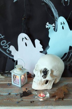 Kafatası, mistik dekor, aydınlatma, dekoratif fener, ahşap bir masada sonbahar yaprakları, Cadılar Bayramı için iç, Ekim