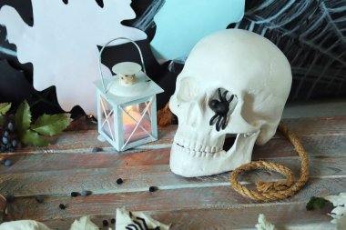 Kafatası, mistik dekor, aydınlatma, dekoratif fener, ahşap bir masada sonbahar yaprakları, Cadılar Bayramı için iç, Ekim