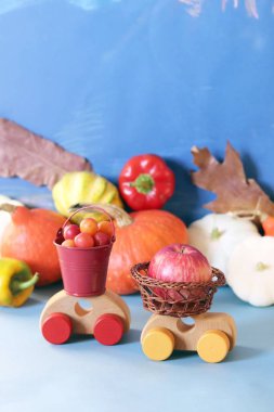 Bir oyuncak araba, kabak, sonbahar sebze, meyve, çiçek ve yaprakları, hasat kavramı, doğal bolluk, Şükran Günü, Cadılar Bayramı dekoratif kompozisyon