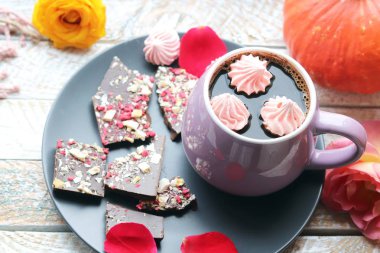 Kahve fincanı, baharatlı çikolata, bezeler, güller, kabaklar, pencere arka planında ahşap bir yüzeyde yapraklar, ev konforu konsepti, Şükran Günü, sonbahar sezonu