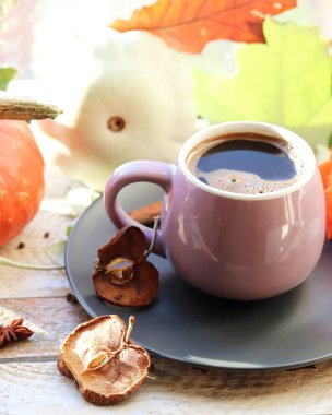 Bir fincan kahve, gül, elma, balkabağı, yapraklar, baharatlar, ahşap bir yüzey üzerinde pencere arkası, ev konforu, Şükran Günü, sonbahar sezonu
