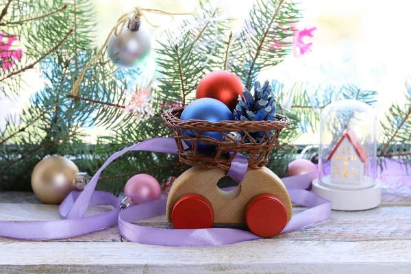 おもちゃの車 クリスマスの装飾 スプルースの枝 窓に対する木製の表面の照明 家庭の快適さ 季節の冬の休日 — ストック写真