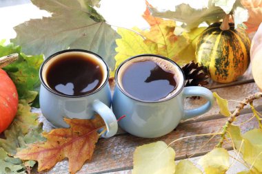İki fincan kahve, kabak, pencerenin arka planında yapraklar, ev konforu kavramı, Şükran Günü, sonbahar sezonu