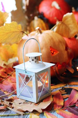 Cadılar Bayramı 'nda balkabağı, lamba, ışık, pencere ve sonbahar yapraklarının arka planında mistik bir dekor mevsimsel tatiller.