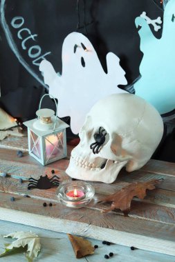 Kafatası, mistik dekor, aydınlatma, dekoratif fener, ahşap bir masada sonbahar yaprakları, Cadılar Bayramı için iç, Ekim