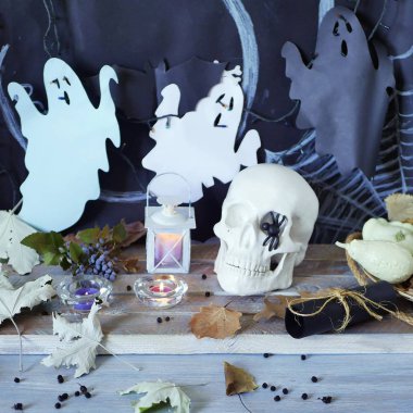 Kafatası, mistik dekor, aydınlatma, dekoratif fener, ahşap bir masada sonbahar yaprakları, Cadılar Bayramı için iç, Ekim