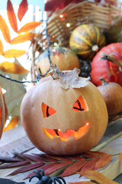 Cadılar Bayramı 'nda balkabağı, lamba, ışık, pencere ve sonbahar yapraklarının arka planında mistik bir dekor mevsimsel tatiller.