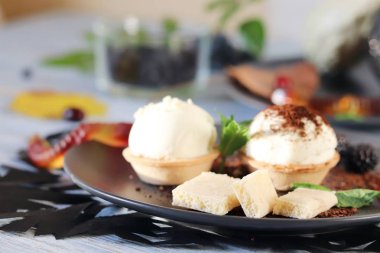 Cadılar Bayramı yemeği, sonbahar yaprakları ve çikolatalı tatlı, dondurma ve jöle solucanları ahşap bir masada.
