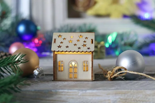 クリスマスの装飾を背景にイルミネーションを持つおもちゃの家 新年の新しい家のコンセプト — ストック写真