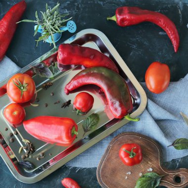 Kırmızı sebzeler, domatesler, biberler, masadaki baharatlar, üst manzara, sağlıklı mevsimlik yiyecek konsepti, ev yemeği.