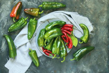 Capsicums kırmızı ve yeşil, baharatlar masada, üst manzara, düz ley, hasat konsepti, sağlıklı mevsimlik yiyecekler, ev yemekleri