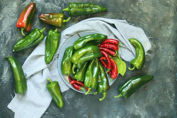 Capsicums kırmızı ve yeşil, baharatlar masada, üst manzara, düz ley, hasat konsepti, sağlıklı mevsimlik yiyecekler, ev yemekleri
