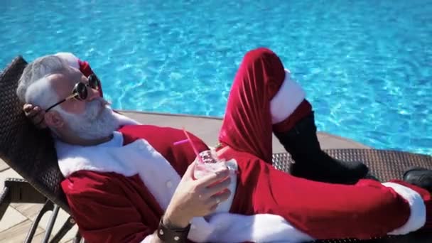 Людина в костюмі Санта релаксація на шезлозі біля басейну — стокове відео