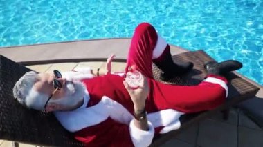 Adam Noel Baba kostüm rahatlama havuzda şezlong üzerinde