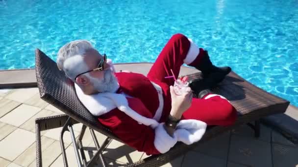 Homme en costume de Père Noël détente sur la piscine de la terrasse — Video