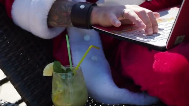 Santa za pomocą laptopa i wpisując w pobliżu basenu — Wideo stockowe