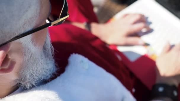 Grappige Santa te typen bij laptop op zomervakantie — Stockvideo