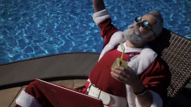 Feliz Santa disfrutar de beber cerca de la piscina — Vídeos de Stock