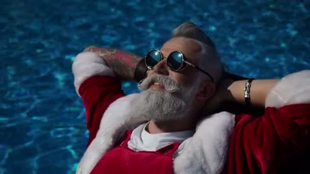 Ευτυχισμένος Santa απολαύσετε ποτό κοντά στην πισίνα — Αρχείο Βίντεο