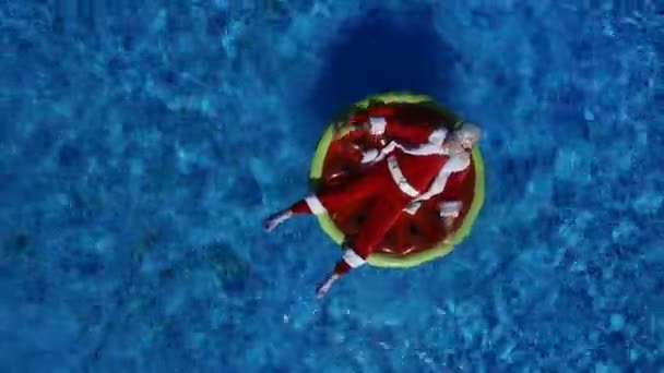 Partij Santa in zwembad op watermeloen float — Stockvideo