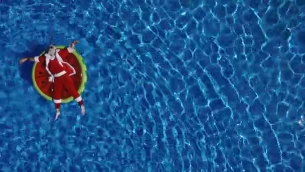 Party Santa in swimming pool on watermelon float — Stock Video