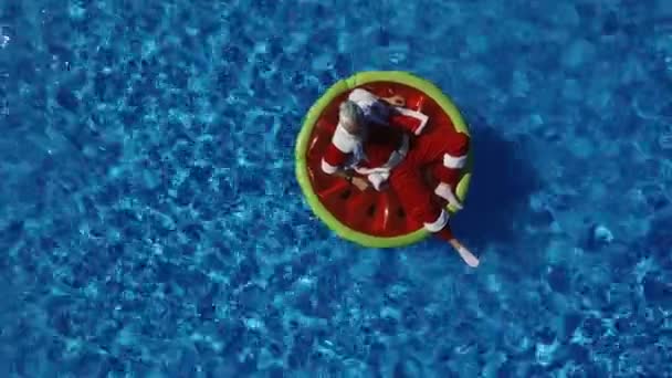 Partij Santa in zwembad op watermeloen float — Stockvideo