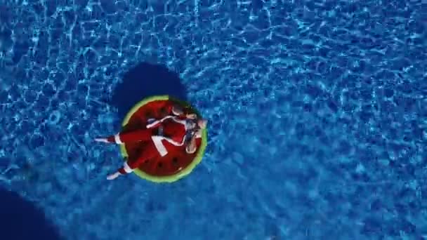Strany Santa v bazénu na plovoucí vodní meloun — Stock video