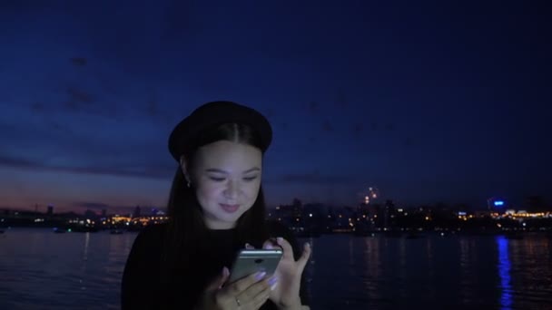 Fireworks and happy girl using phone at embankment — Stock Video